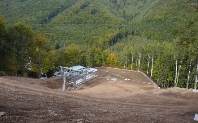 Mur oporowy wyrównujący stromy teren stacji kolei linowej na stoku w Klínych