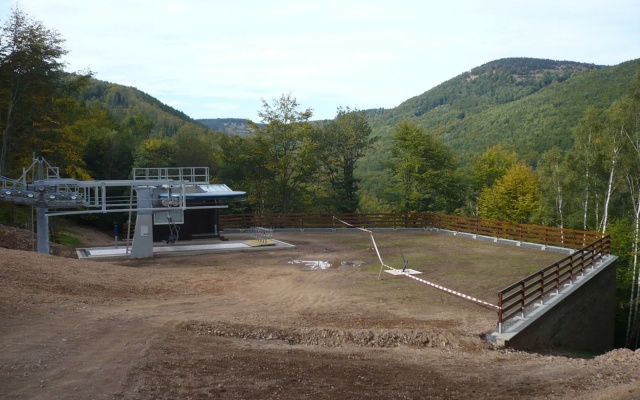 Mur oporowy wyrównujący stromy teren stacji kolei linowej na stoku w Klínych