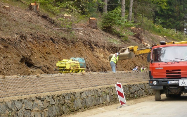 Wysokie oddzielenie drogi i ścieżki rowerowej stromym zboczem w Prášilech na Szumawie
