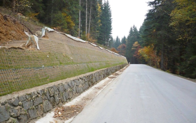 Wysokie oddzielenie drogi i ścieżki rowerowej stromym zboczem w Prášilech na Szumawie