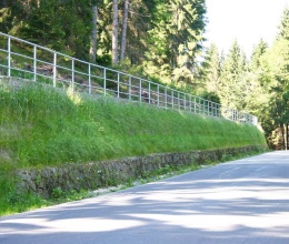 Wysokie oddzielenie drogi i ścieżki rowerowej stromym zboczem w Prášilech na Szumawie